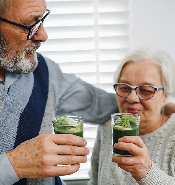 Happy couple enjoying green powder supplements