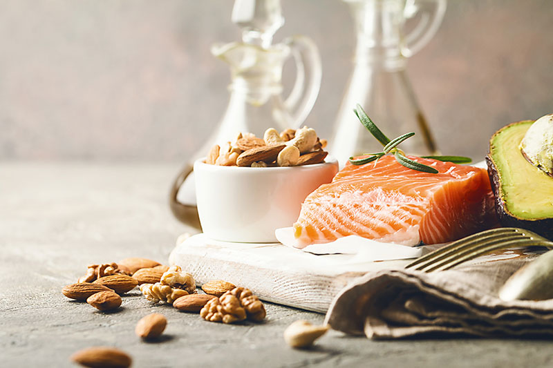 Healthy fats in nutrition - salmon, avocado, oil, nuts. Concept of healthy food